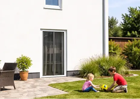 Insektenschutz für Terrassentüren bei Haus und Garten Kinder spielen im Garten vor einer Terrassentür mit Insektenschutzgitter